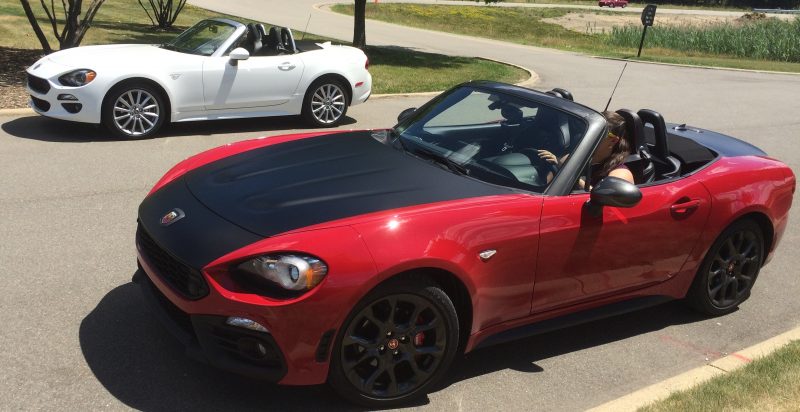 Red Fiat 124 Spider Abarth (front) and white Fiat 124 Spider (rear).